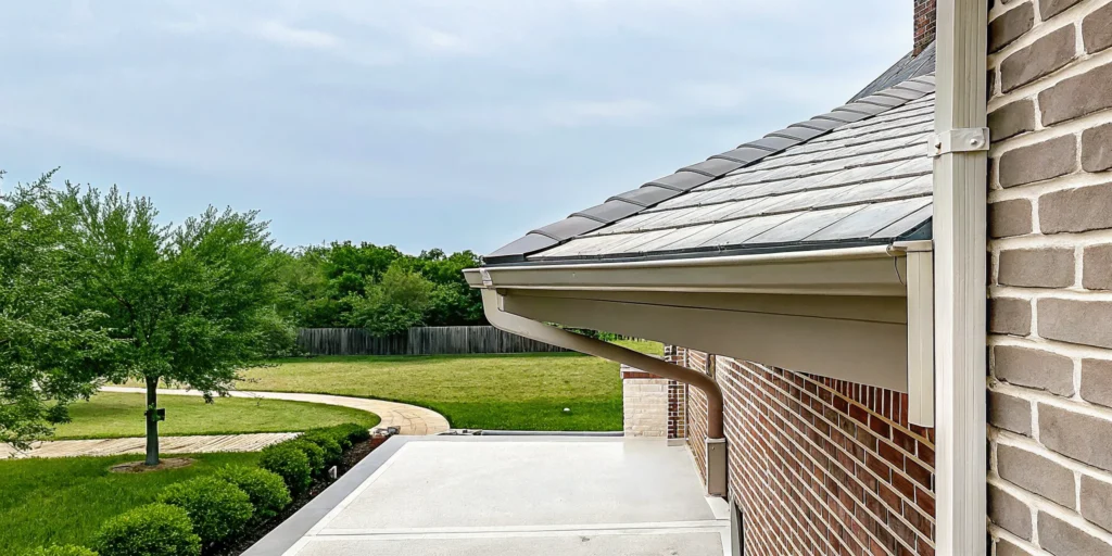 Gutter and downspout directing rainwater away from a Texas home foundation